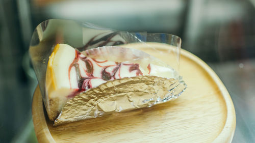 High angle view of dessert in plastic container on wooden plate