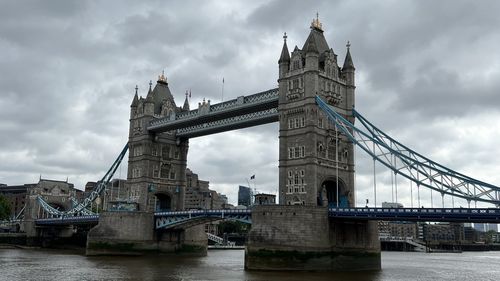 View of tower bridge over river against cloudy sky
