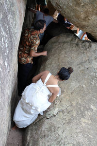 High angle view of people sitting on rock