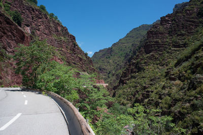 Road amidst plants and mountains against sky