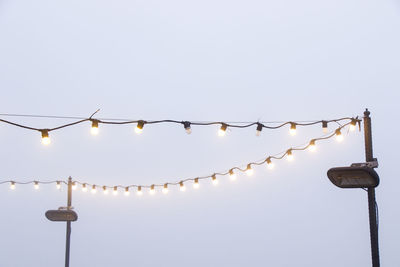 Low angle view of illuminated street light against clear sky