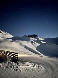 Scenic view of snowcapped mountains against sky at night