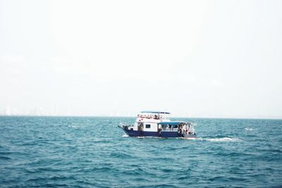 Boat sailing in sea against sky