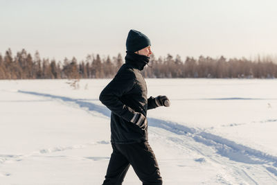 Full length of man standing on snow covered field