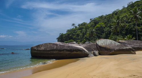 Rocks on beach against sky