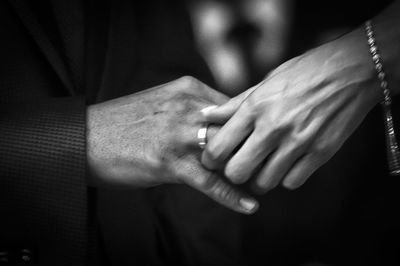 Cropped hand of bride putting ring in groom finger