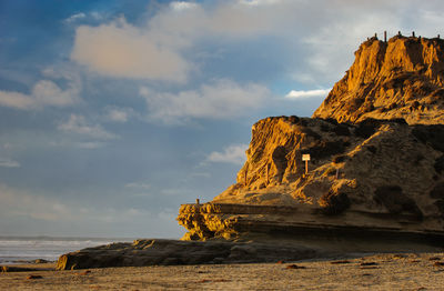 Rock formations by sea against sky