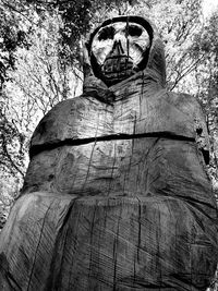 Low angle view of statue against tree trunk