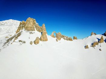 Scenic view of snowcapped mountains against clear blue sky