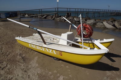 Yellow boat moored at beach