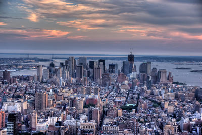 Aerial view of buildings against cloudy sky during sunset