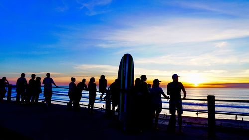 People at beach during sunset