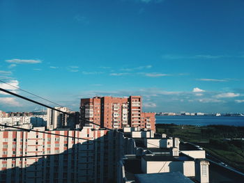 Buildings in city against blue sky