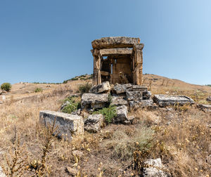 Old ruin on field against clear blue sky