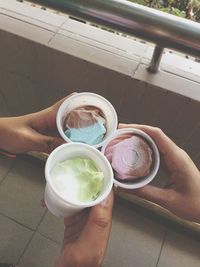 Cropped hands of friends toasting ice creams