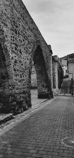 Footpath by old building against sky