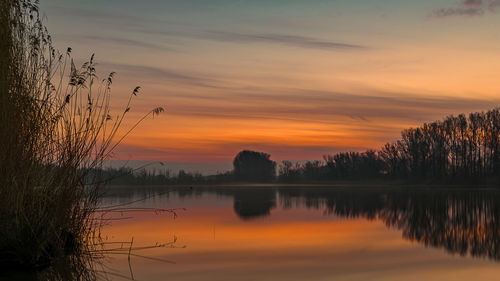 Scenic view of lake against orange sky