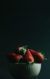 Close-up of strawberries on table against black background