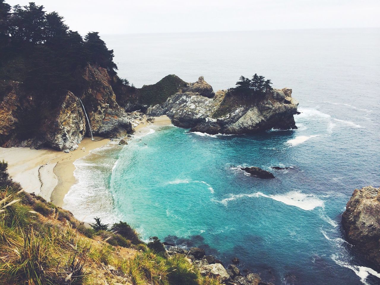 sea, water, horizon over water, beach, scenics, tranquil scene, tranquility, beauty in nature, shore, high angle view, rock - object, nature, coastline, rock formation, idyllic, cliff, blue, sky, tree, clear sky