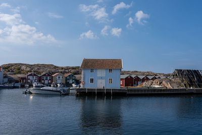 Buildings at waterfront against cloudy sky