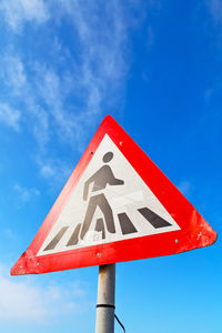 Road sign against blue sky