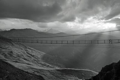 Scenic view of bridge over mountains against sky