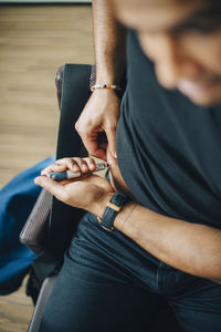 High angle view of businessman injecting insulin in abdomen while sitting in office