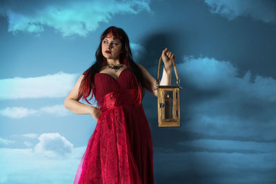 Young woman standing against sky