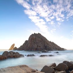 Rocks on sea shore against sky
