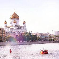 Boats in river with city in background