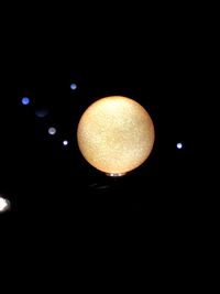 Low angle view of illuminated lights against sky at night