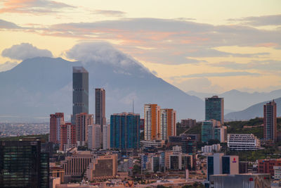 Buildings in city against sky during sunset