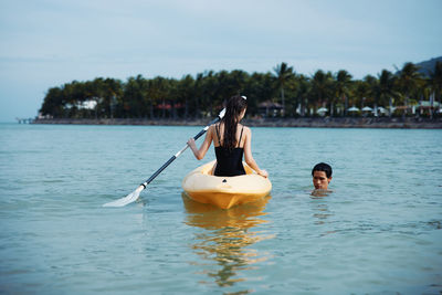 Rear view of woman swimming in sea