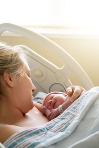 Portrait of cute baby boy lying on bed at home