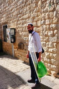 Side view of man standing against wall