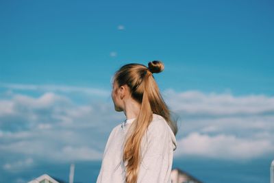 Low angle view of woman standing against sky