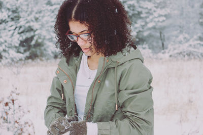 Young woman wearing warm clothing standing outdoors during winter