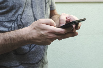 Midsection of man using mobile phone