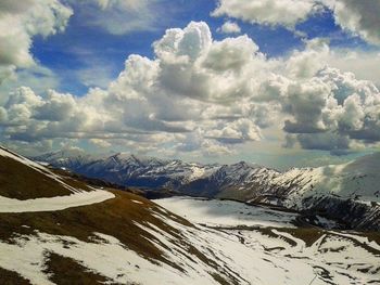 Snow covered mountains against cloudy sky