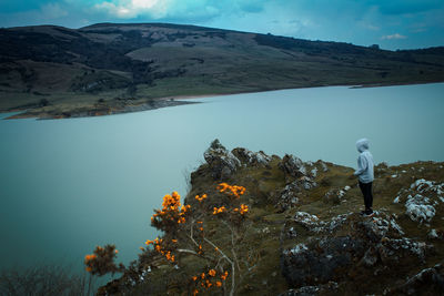 Woman standing on rock by lake