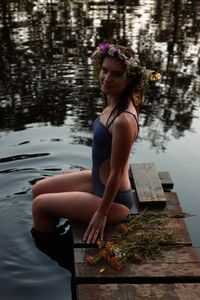 Young woman sitting by lake
