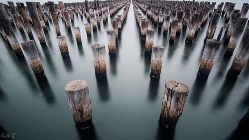 High angle view of wooden posts in river