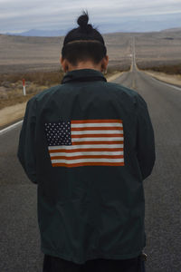 Rear view of person with american flag shirt on road