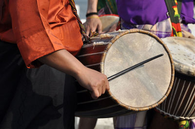 Midsection of men playing drums