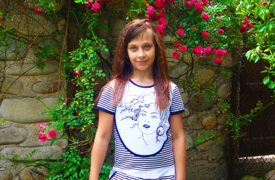 Portrait of smiling girl standing against trees