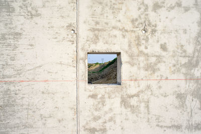 Mountain seen through hole in wall