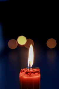 Close-up of lit candle on table