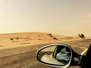 Car in desert against clear sky