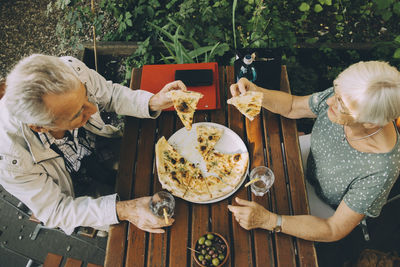 Rear view of people having food on table