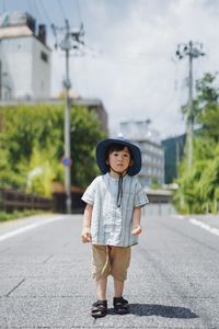 Portrait of young woman standing on road